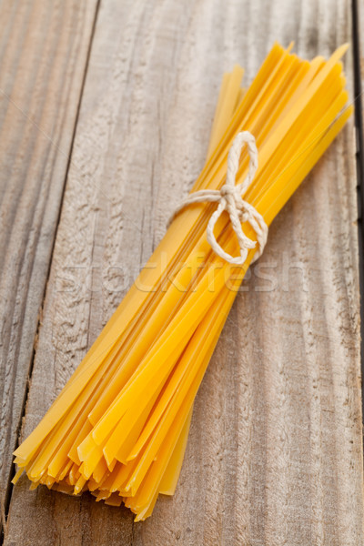 Foto d'archivio: Tagliatelle · pasta · essiccati · tavolo · in · legno · sfondo · cucina