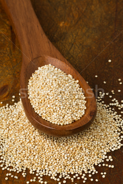 Raw, whole, unprocessed quinoa seed in wooden spoon on wood boar Stock photo © ShawnHempel