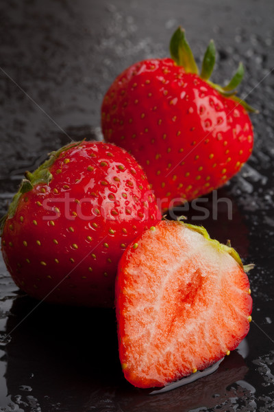 Three strawberries on black with water drops Stock photo © ShawnHempel