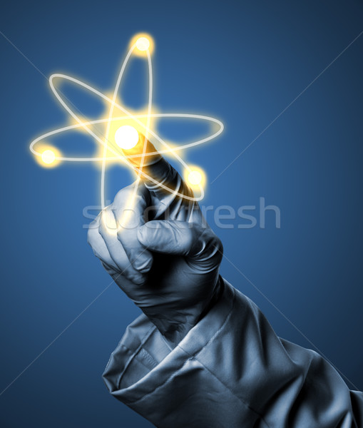 Researcher or scientist with rubber glove holding glowing atom m Stock photo © ShawnHempel