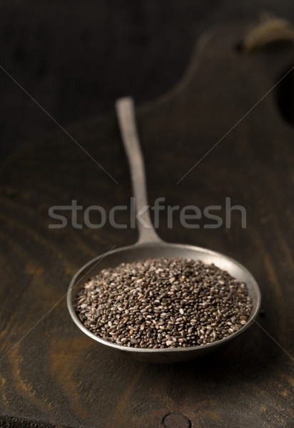 Raw unprocessed black chia seeds in metal spoon on wooden board Stock photo © ShawnHempel