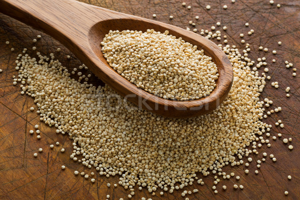 Raw, whole, unprocessed quinoa seed in wooden spoon on wood boar Stock photo © ShawnHempel