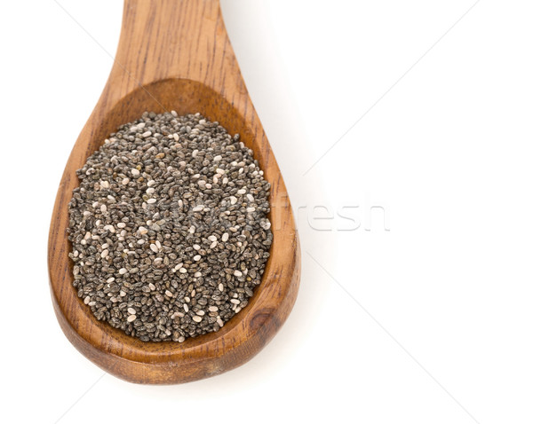 Whole dried black chai seeds in wooden spoon Stock photo © ShawnHempel
