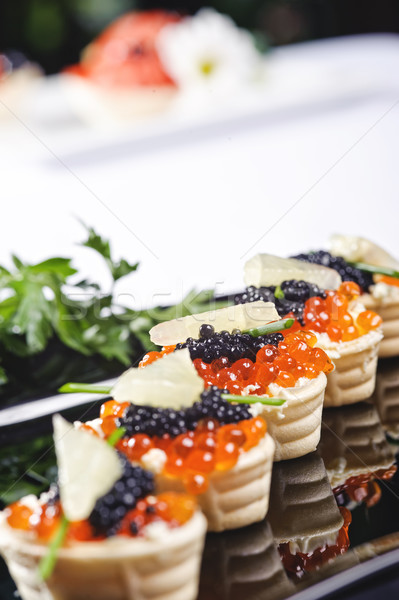 Harapnivalók lazac ikra zöldségek fekete tányér Stock fotó © shivanetua