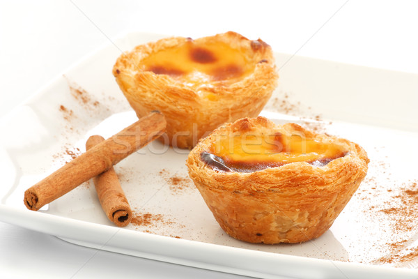 Custard Pies over a white plate with cinnamon sticks Stock photo © simas2