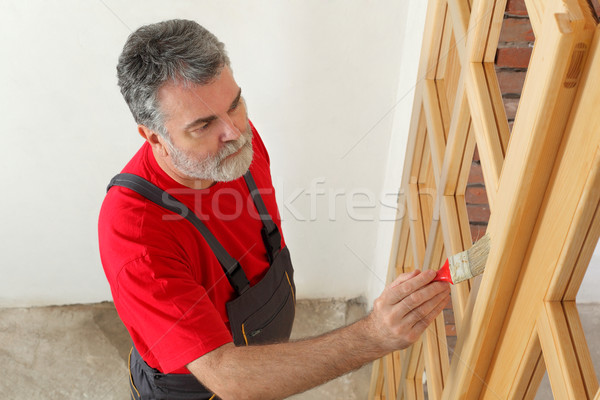 Home renovation, worker painting wooden door, varnishing Stock photo © simazoran