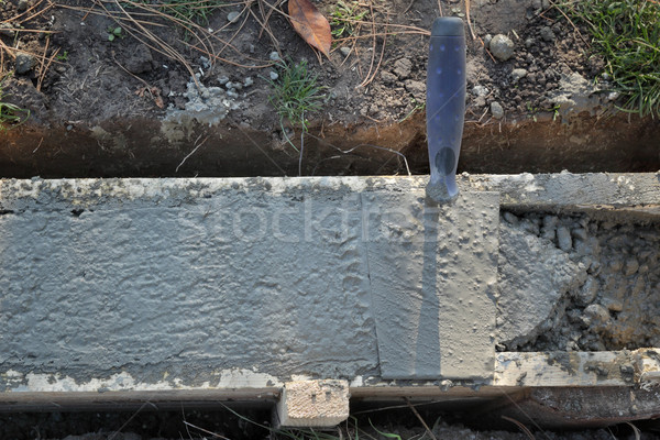 Trowel at wall foundation, concrete in formwork and tool Stock photo © simazoran