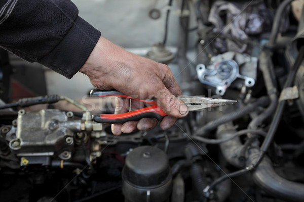 Stock photo: Car mechanic hold pliers tool in hand