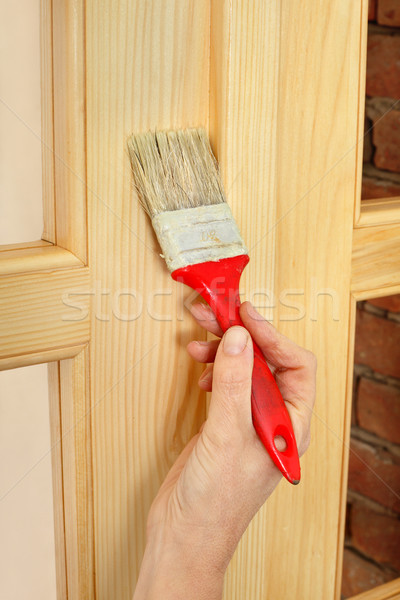 Home renovation, worker painting wooden door, varnishing Stock photo © simazoran