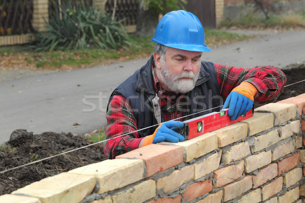 Worker examining brick wall Stock photo © simazoran