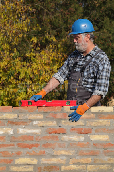 Worker examining brick wall Stock photo © simazoran