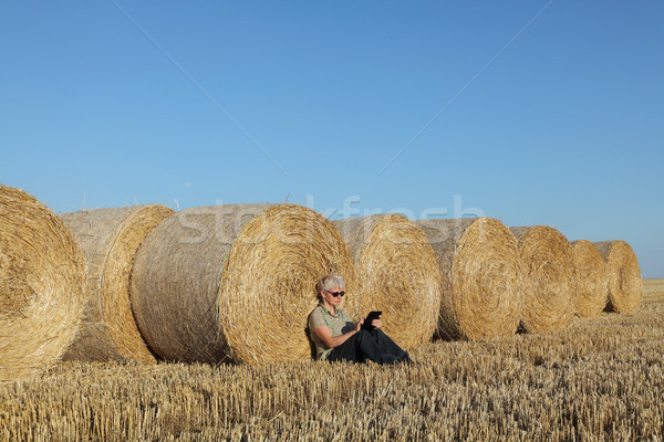 Farmer examining wheat field after harvest using tablet Stock photo © simazoran