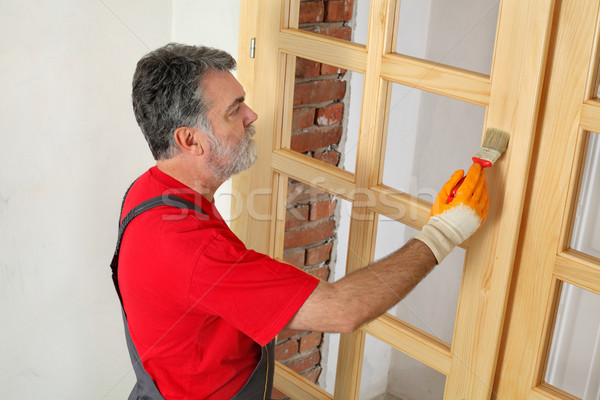 Home renovation, worker painting wooden door, varnishing  Stock photo © simazoran