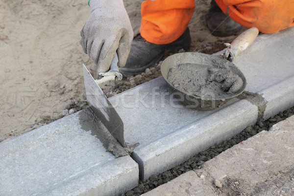 Kőműves munkás installál kő kéz út Stock fotó © simazoran