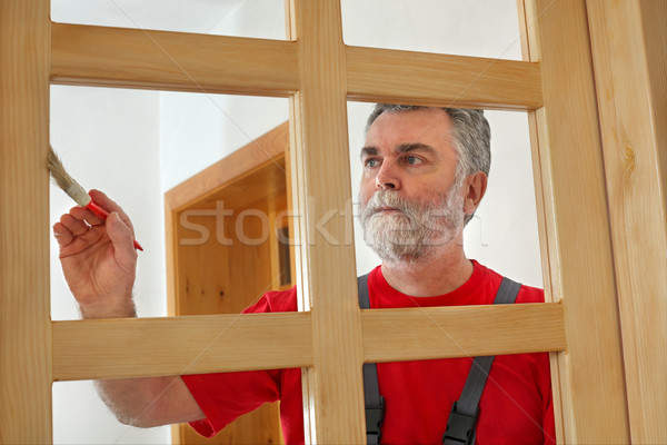 Home renovation, worker painting wooden door, varnishing  Stock photo © simazoran