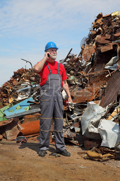 Recycling industry, worker using phone and heap of old metal Stock photo © simazoran