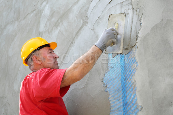 Wall insulation, spreading mortar over mesh Stock photo © simazoran