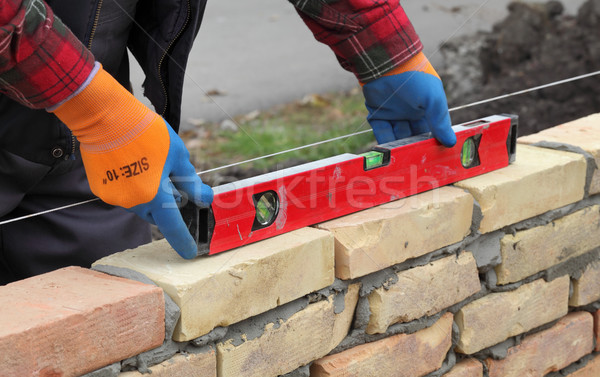 Worker examining brick wall Stock photo © simazoran