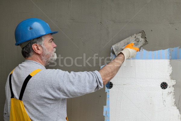 Wall insulation, spreading mortar over mesh and styrofoam Stock photo © simazoran
