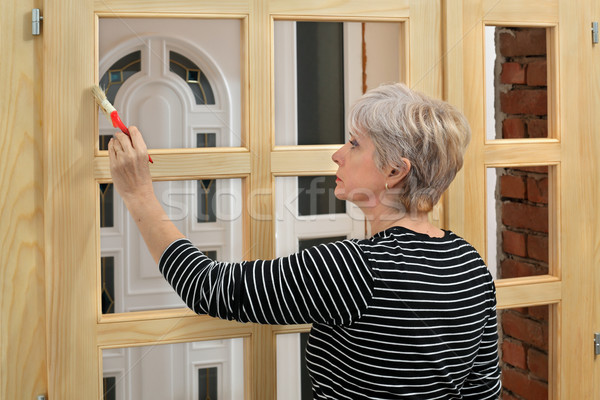 Home renovation, worker painting wooden door, varnishing  Stock photo © simazoran