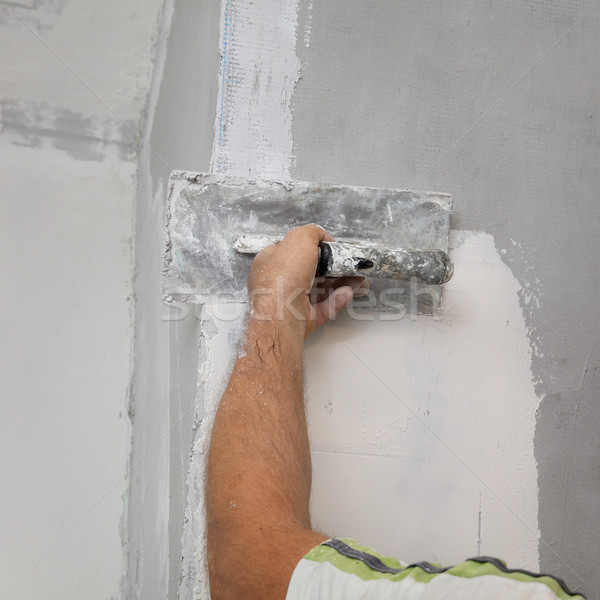 Worker spreading plaster to wall Stock photo © simazoran