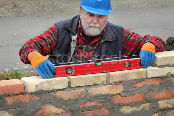 Worker examining brick wall Stock photo © simazoran
