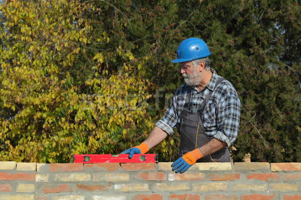 Worker examining brick wall Stock photo © simazoran