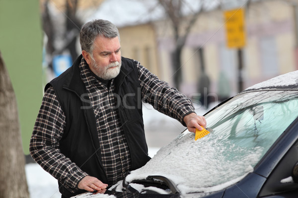 Winter scene, driver cleaning windshield of car Stock photo © simazoran