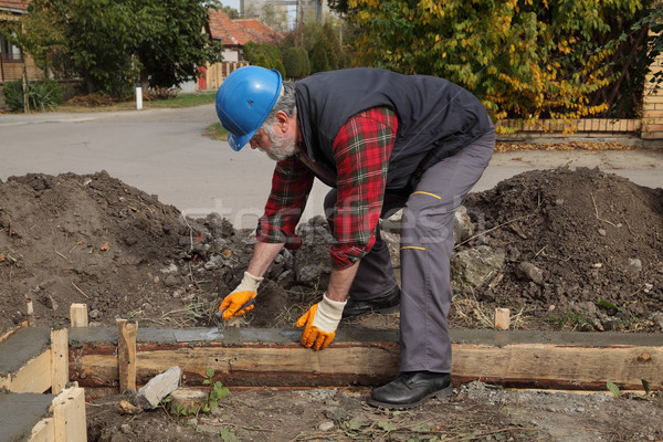 Construction worker making concrete foundation in formwork Stock photo © simazoran