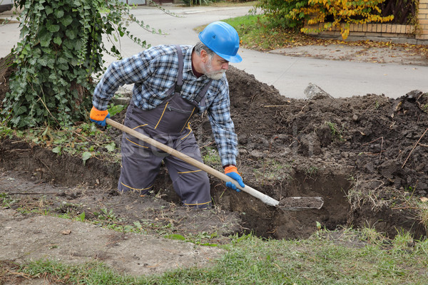 Construction worker digging trench using shovel Stock photo © simazoran