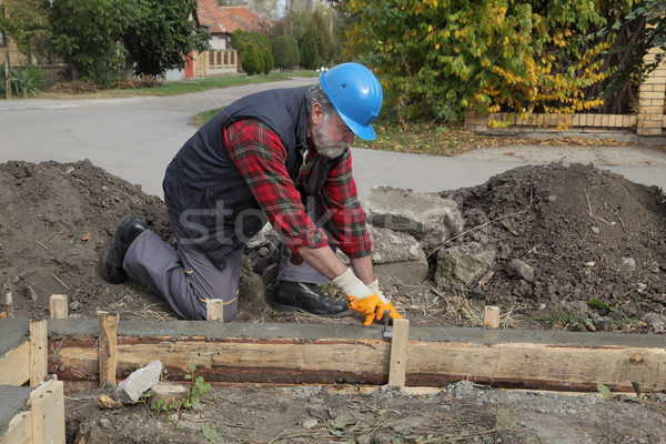 Construction worker making concrete foundation in formwork Stock photo © simazoran