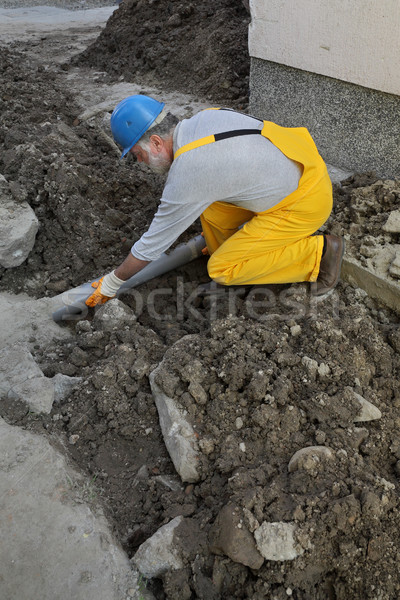 Plumber at construction site repair sewerage tube Stock photo © simazoran