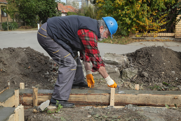 Construction worker making concrete foundation in formwork Stock photo © simazoran