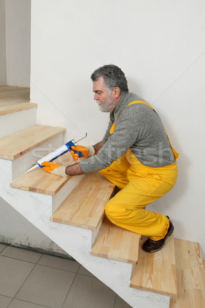 Home renovation, caulking wooden stairs with silicone Stock photo © simazoran