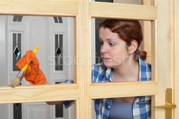 Young girl worker, painting new wooden door Stock photo © simazoran