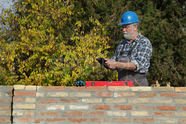 Stock photo: Worker examining brick wall