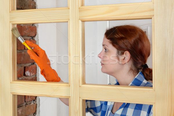 Young girl worker, painting new wooden door Stock photo © simazoran