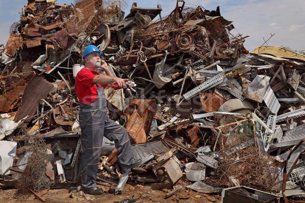 Recycling industry, worker using phone at heap of old metal Stock photo © simazoran