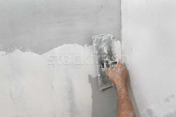 Worker spreading plaster to damaged wall Stock photo © simazoran