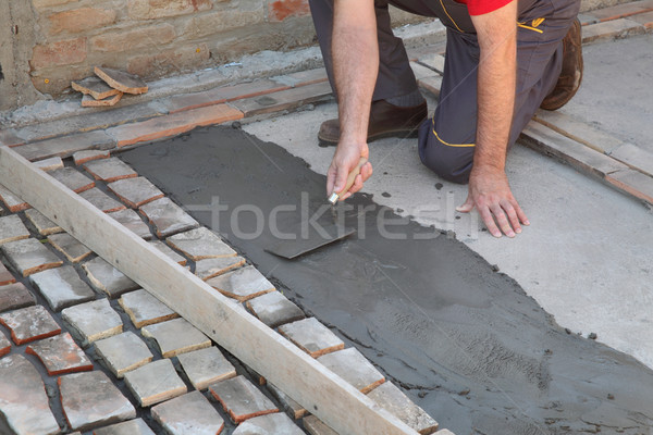 Pavement or terrace making, worker spreading mortar Stock photo © simazoran