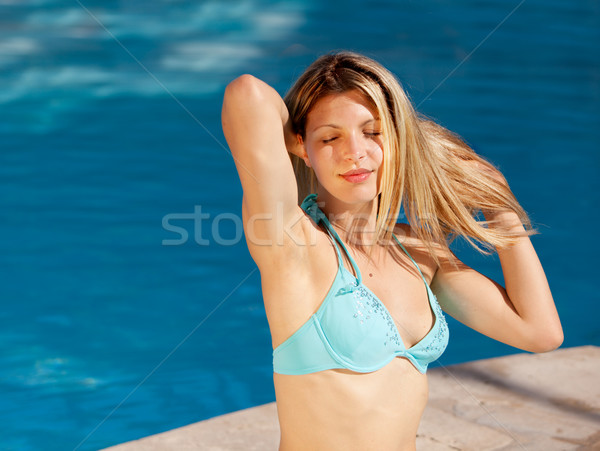 Frau Sonnenbräune außerhalb Pool genießen Sonne Stock foto © SimpleFoto