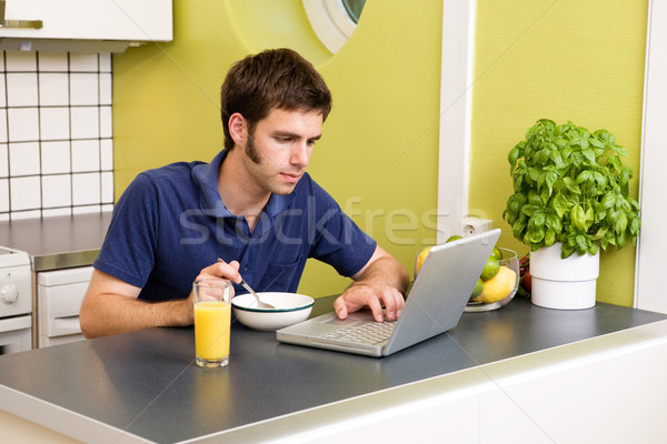 Cucina computer lavoro giovani maschio mangiare Foto d'archivio © SimpleFoto