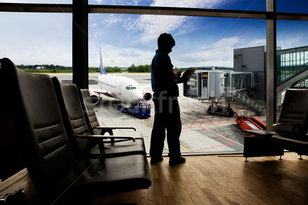 Aéroport ordinateur jeune homme utilisant un ordinateur portable homme portable [[stock_photo]] © SimpleFoto