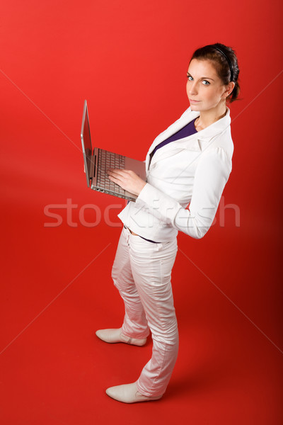 Feminino computador vermelho mulher jovem datilografia computador portátil Foto stock © SimpleFoto