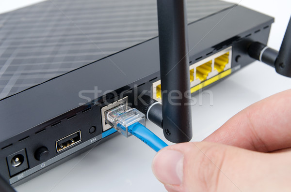 Man plugs internet cable into the router Stock photo © simpson33