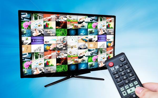 TV with multiple images gallery on blue background. Hand hold re Stock photo © simpson33