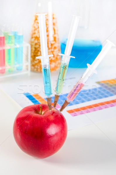 Stock photo: Three syringes in red apple. Genetically modified food concept.