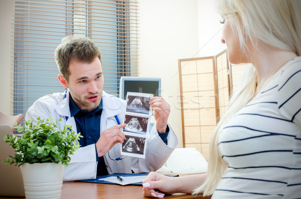 Doctor showing baby ultrasound image to pregnant woman Stock photo © simpson33