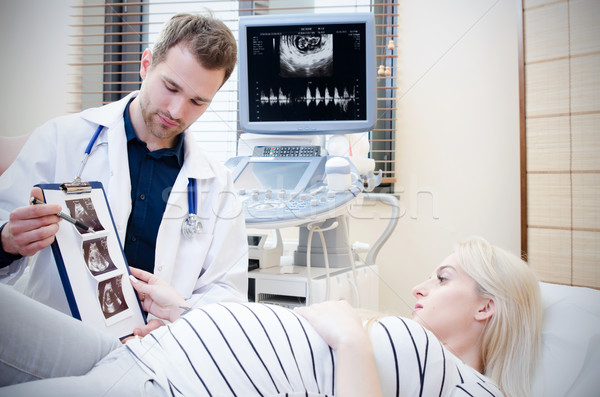 Doctor showing baby ultrasound image to pregnant woman. Stock photo © simpson33
