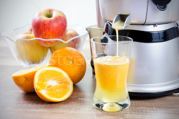 Juicer and orange juice. Fruits in background Stock photo © simpson33